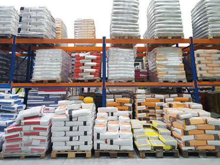 Professional construction materials delivery truck with workers unloading building supplies at a construction site